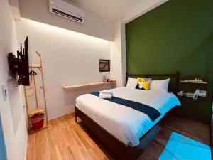 鱼池乡日月潭沅居民宿 YUAN JU BOUTIQUE Hotel的一间卧室设有一张大床和绿色的墙壁