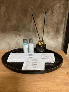 彼得罗巴甫洛夫斯克DEMAL HOTEL的一张桌子,上面有黑色的盘子,上面有两瓶化妆品