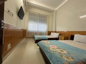 波来古市MoTel HỒ XUÂN的酒店客房设有两张床和窗户。