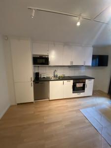 哥德堡Norhemsgatsn 23的厨房配有白色橱柜和黑色台面