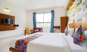 班加罗尔FabHotel Emirates Suites的卧室设有一张白色大床和一扇窗户。