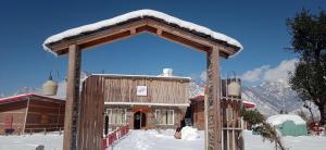 ShangarhHiraeth Shangarh, Sainj Valley的一座有雪的木制建筑