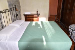 GrumoAgriturismo Grabbia的一张绿色和白色的床,位于带桌子的房间