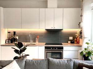 奥胡斯Your Perfect Aarhus Staycation的厨房配有白色橱柜和沙发。