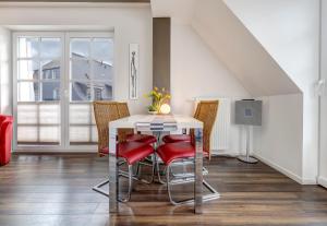 巴尔姆Residenz am Balmer See - BS 71 mit Wellnessbereich的一间带桌子和红色椅子的用餐室