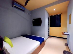 孟买Hotel Aspen - Near Airport的一间小卧室,配有一张床和电视