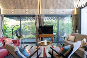 纳西克StayVista's Celeste Villa - Hill-View Retreat with Infinity Pool & Outdoor Jacuzzi的客厅配有沙发、椅子和电视