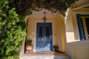 爱琴娜岛Villa Elmar的两棵盆栽植物的房子的蓝色前门