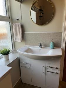 奥马Kingarrow Cottage的浴室设有白色水槽和镜子