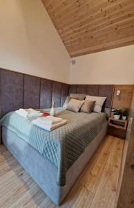 OsłoninoNowe Domki Deluxe z widokiem na zatokę z basenem i sauną的卧室内的一张大床,拥有木制天花板