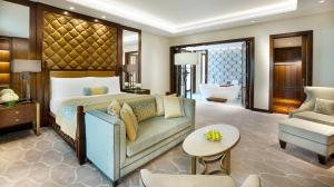 迪拜迪拜丽思卡尔顿酒店的一间卧室配有一张床、一张沙发和一把椅子
