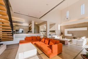 伊利索斯菲勒利莫斯绿洲别墅的开放式客厅配有橙色家具和厨房