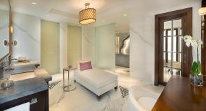 迪拜迪拜丽思卡尔顿酒店的一间带椅子、水槽和浴缸的浴室
