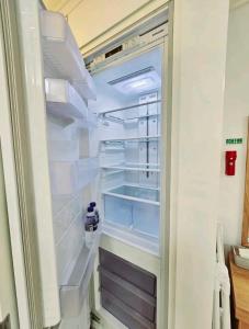 釜山Jeoung's House的配有一瓶水的开放式冰箱