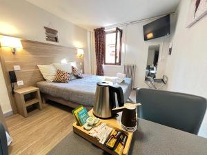 巴斯洛内特杜切瓦布兰克酒店的酒店客房配有一张床、一张桌子和咖啡壶