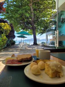 贝卢港Pousada Vila Verde的餐桌上两盘早餐食品,海滩上