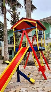 贝卢港Pousada Vila Verde的一座建筑前方的游乐场,有五彩缤纷的游戏结构