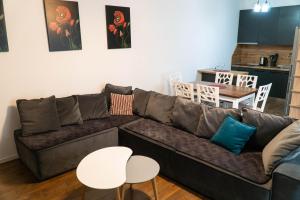 地拉那Signature apartment 5的客厅配有棕色沙发和白色桌子