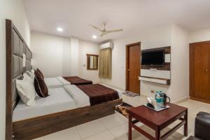 新德里Hotel South Indian的一间酒店客房,配有一张床和一台电视