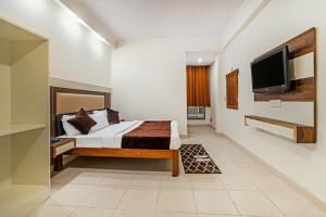 新德里Hotel South Indian的一间卧室配有一张床和一台平面电视