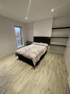 贝尔法斯特OYO Queens Quarter的一间卧室配有一张床,铺有木地板