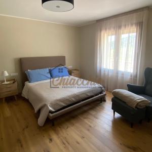CollepardoVilla La Macchia的卧室配有床、椅子和窗户。