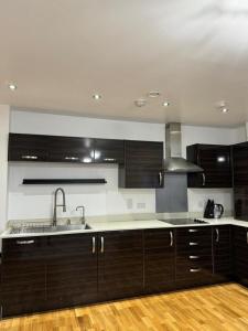 达特福德Stunning 2-Bed Apartment in Dartford的厨房配有深色木质橱柜和水槽。