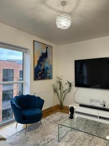 达特福德Stunning 2-Bed Apartment in Dartford的客厅配有蓝色椅子和平面电视