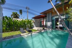 奈汉海滩Onyx Villas by TropicLook的房屋前的游泳池