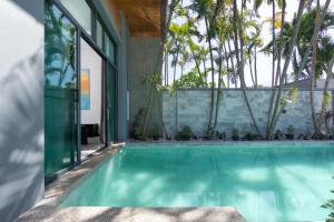 奈汉海滩Onyx Villas by TropicLook的棕榈树房子中的游泳池