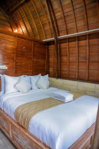 塔巴南Abing Dalem - Villa Nangka的木墙客房内的一张大床