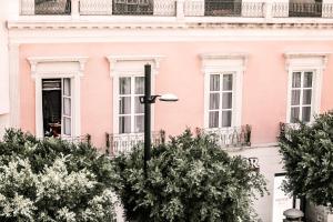 阿尔么丽亚HO Paseo de Almería的前面有树木的粉红色建筑