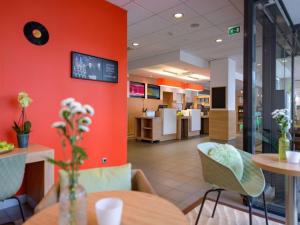 海尔布隆海尔布隆宜必思酒店的餐厅拥有橙色的墙壁和桌椅