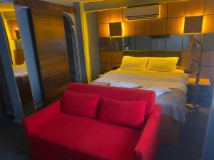 伊斯坦布尔Kadıköy Linda Hotel的红色的沙发和客房内的一张床