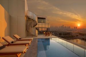 迪拜Hilton Dubai Creek Hotel & Residences的一座建筑屋顶上的游泳池,享有美景