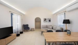 Agia ParaskeviBeautiful Santorini Villa - 3 Bedroom Villa - Private Jacuzzi and Charismatic Interior - Vothonas的客厅配有沙发和桌子