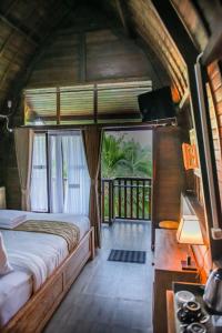 塔巴南Abing Dalem - Villa Durian的一间卧室设有一张床和一个阳台
