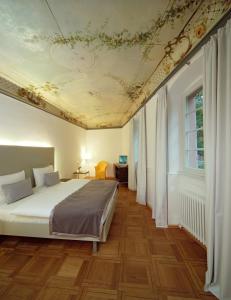 海德堡海德堡艺术酒店的一间卧室设有床铺和鲜花天花板