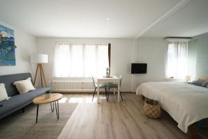 法伦湖Bijou Studio with Ambiance near Lake的一间卧室配有一张床、一张沙发和一张桌子