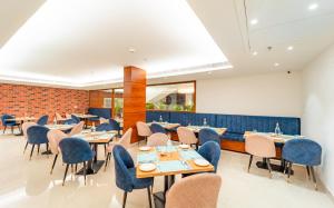 齐拉克普尔Playotel Inn, Chandigarh的一间带桌椅的餐厅以及砖墙