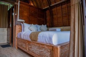 塔巴南Abing Dalem - Villa Mangga的一间卧室配有一张带木墙的大床