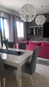 内比达Casa vacanza Maligio' Nebida Masua的客厅配有桌子和粉红色的沙发