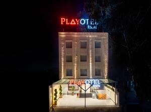 齐拉克普尔Playotel Inn, Chandigarh的上面有一个 ⁇ 虹灯标志的酒店