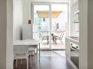 塔维亚诺Relais San Martino Salento - Handwritten Collection的厨房以及带桌椅的用餐室。