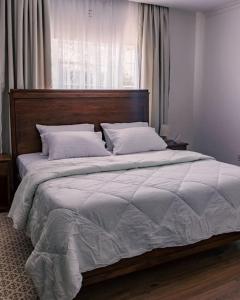 纳纽基Silverbeck Residence, Nanyuki的卧室内的一张带木制床头板的大床