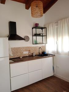 塞尔塞迪利亚Casita independiente con jardin的厨房配有白色橱柜和水槽