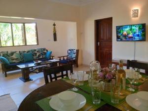 迪亚尼海滩Tahira Villa的一间带桌子的用餐室和一间客厅