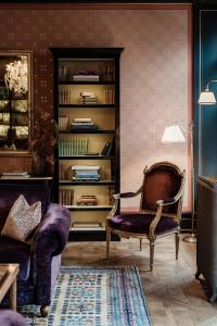 巴塞尔Grand Hotel LES TROIS ROIS的客厅配有椅子和书架