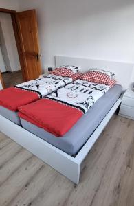 BeinwilRuheort的一张带红白毯子和枕头的床