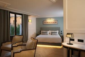 萨拉曼卡Eunice Hotel Gastronómico的酒店客房带一张床、一张桌子和椅子
